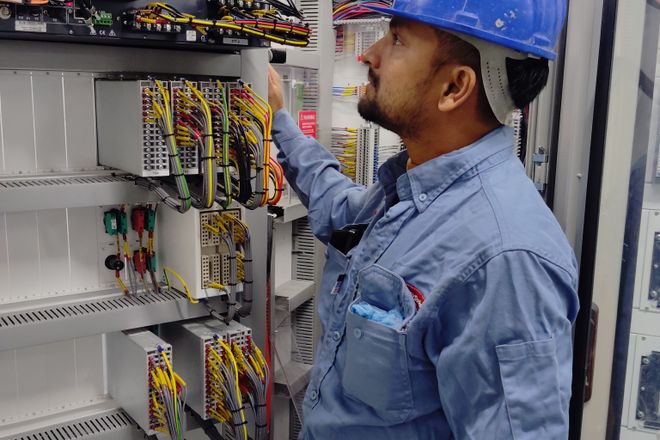Técnico revisando el cableado de un tablero de control industrial