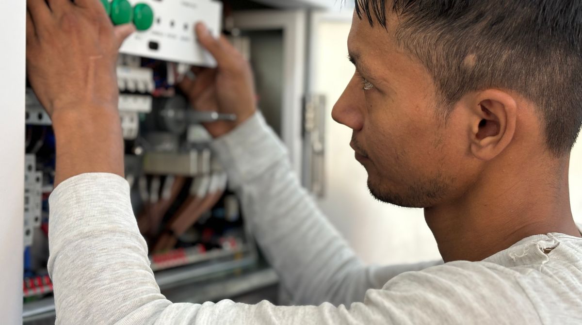 Electricista revisando las conexiones de un tablero eléctrico