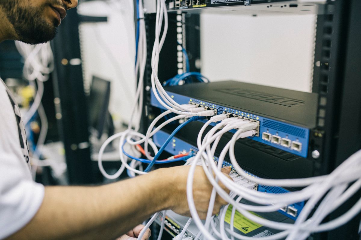 Técnico conectando cables de red en un rack